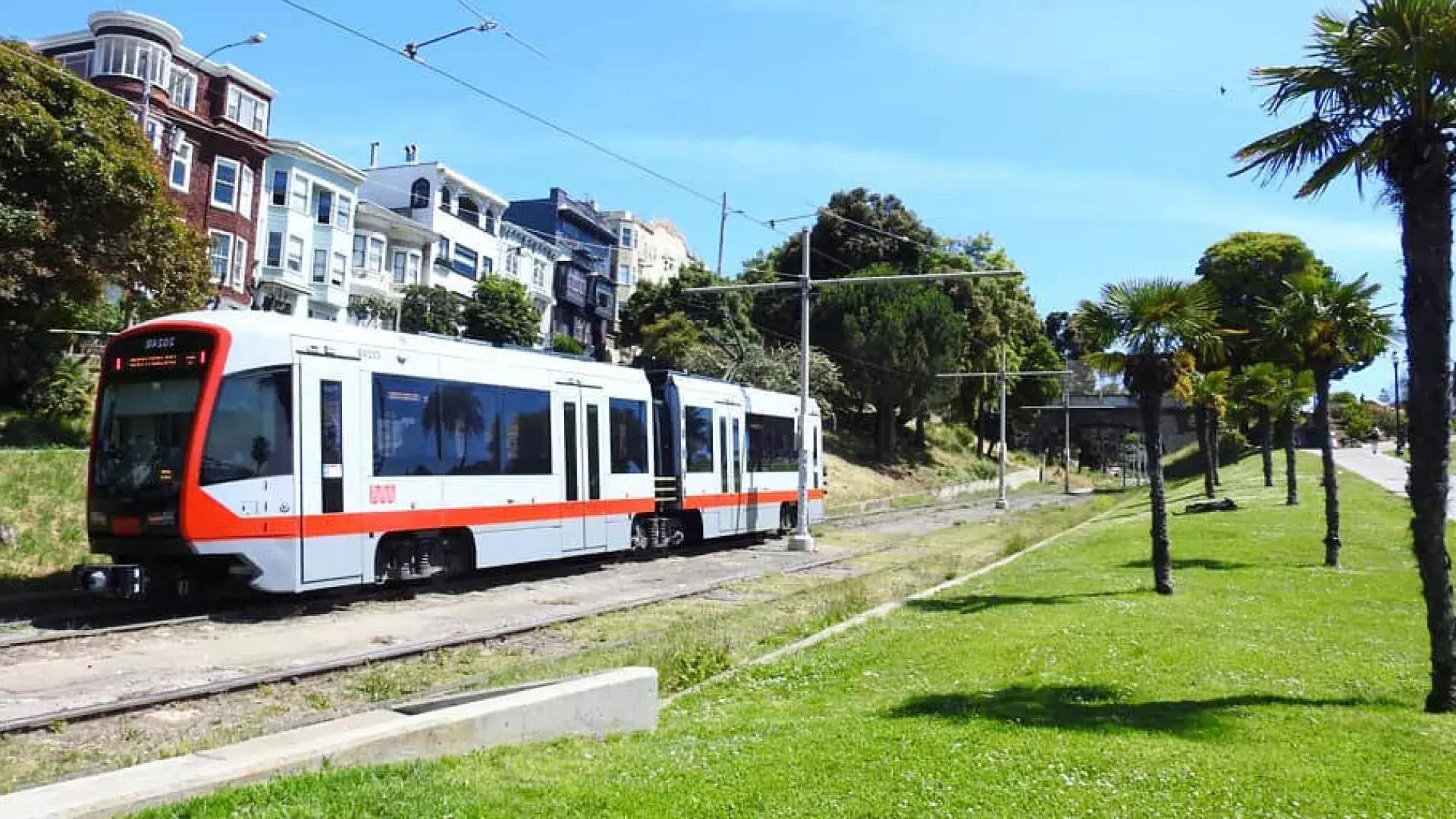 A MUNI passenger train runs along a track in San Francisco.