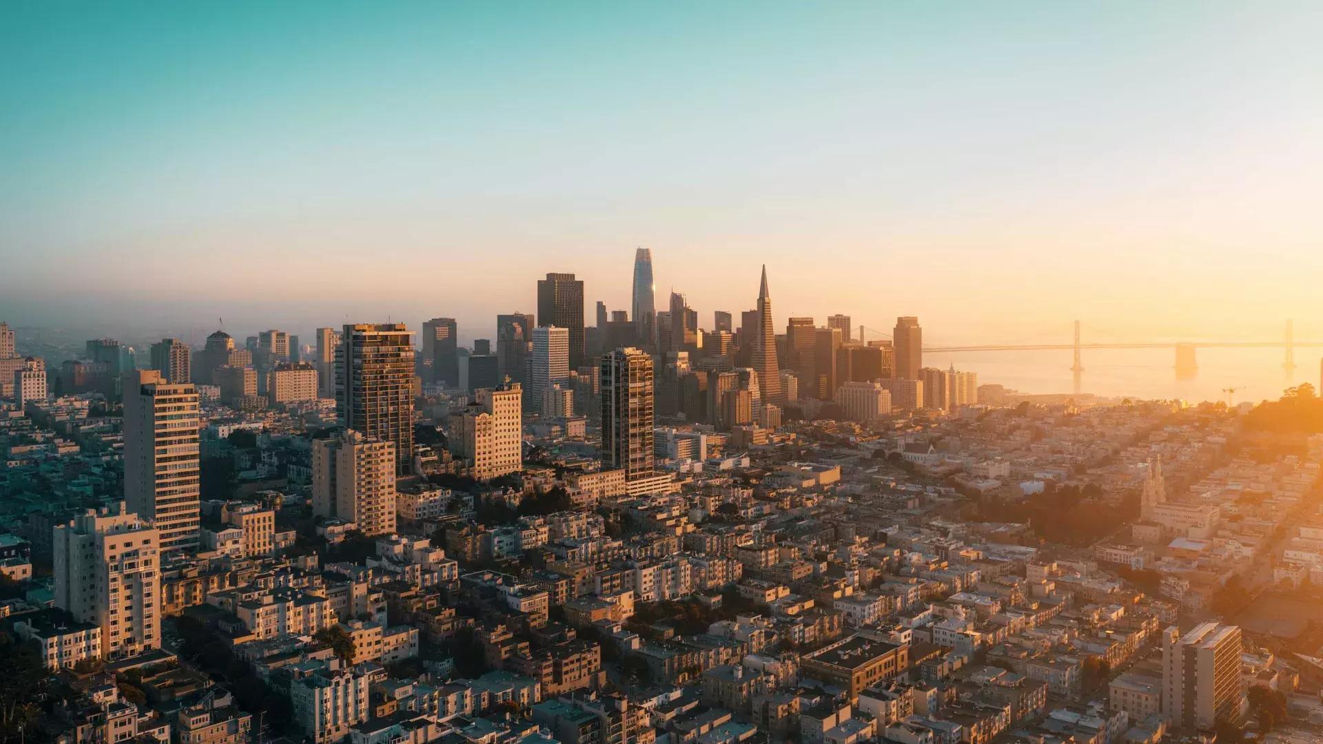샌프란시스코의 스카이라인이 황금빛으로 공중에서 보입니다.