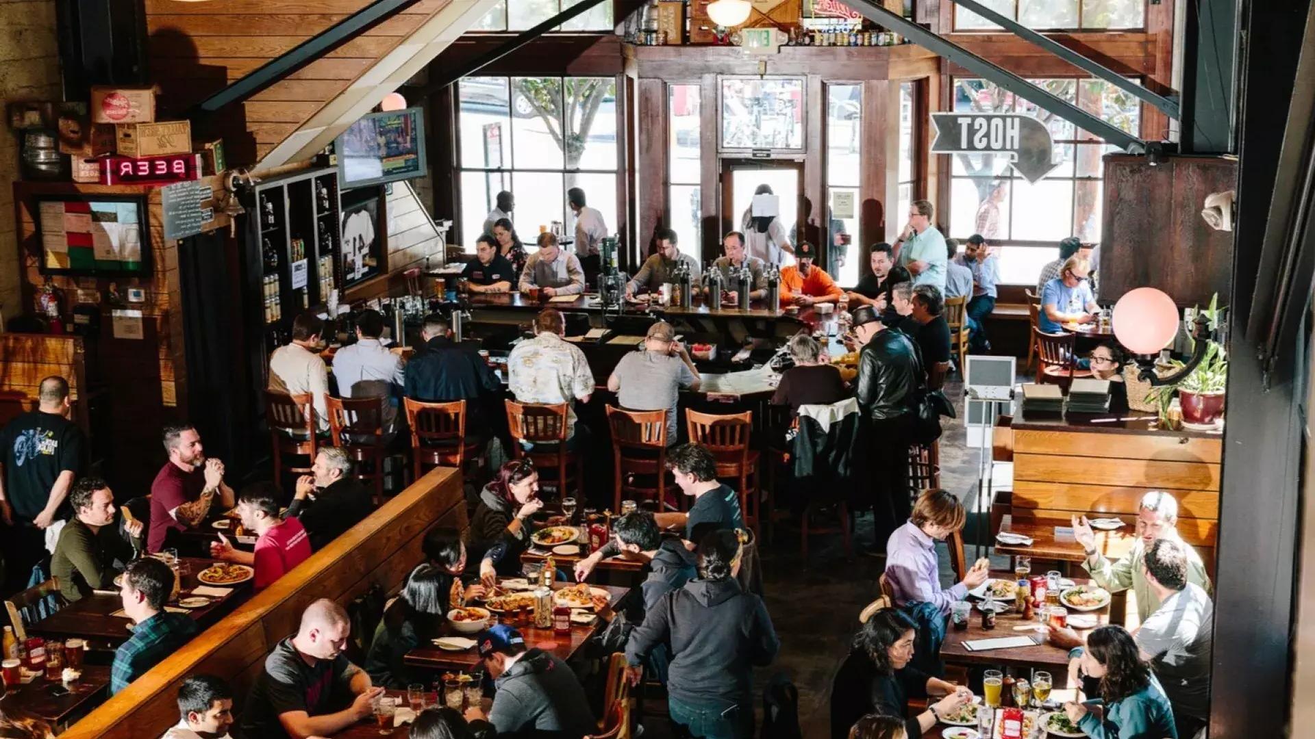 Gli avventori mangiano e bevono all'interno del birrificio 21st Amendment a San Francisco.
