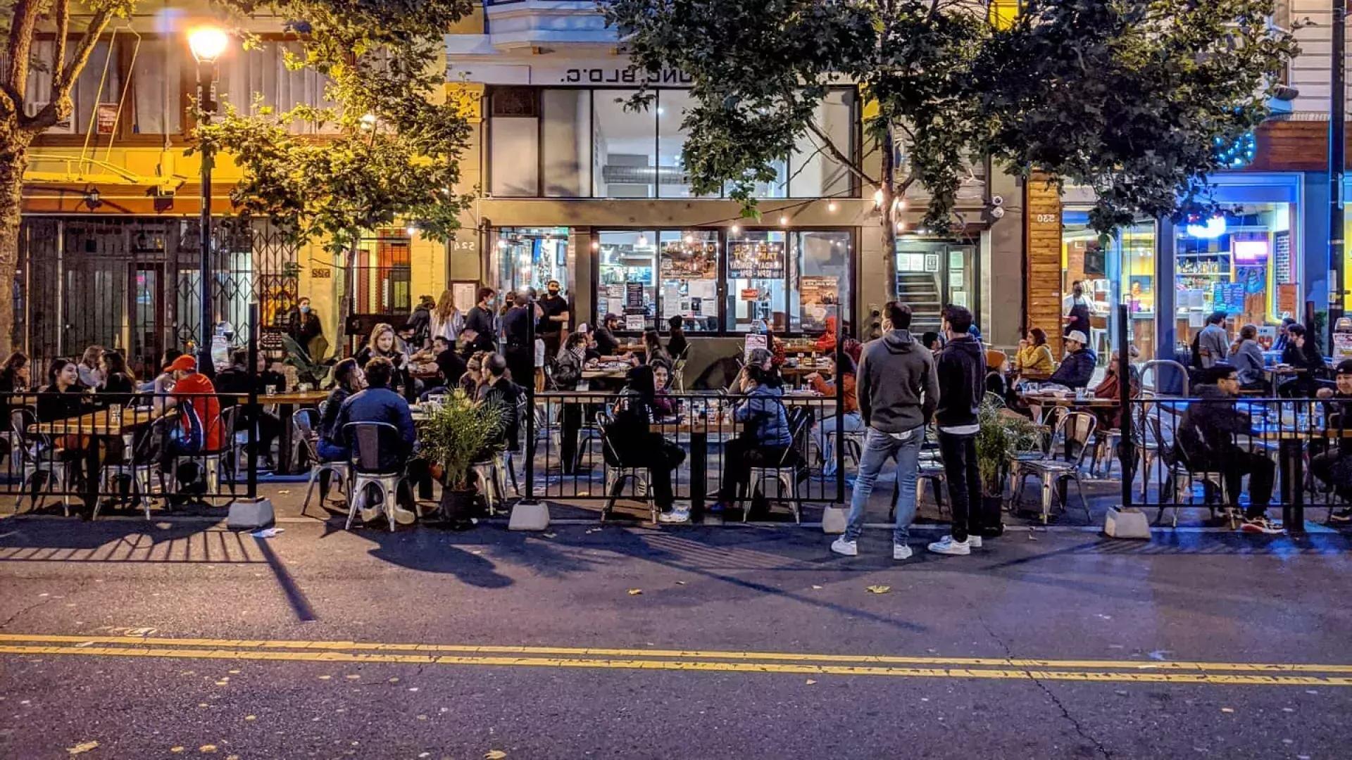 A crowd enjoys food 和 drink along San Francisco's Valencia Street