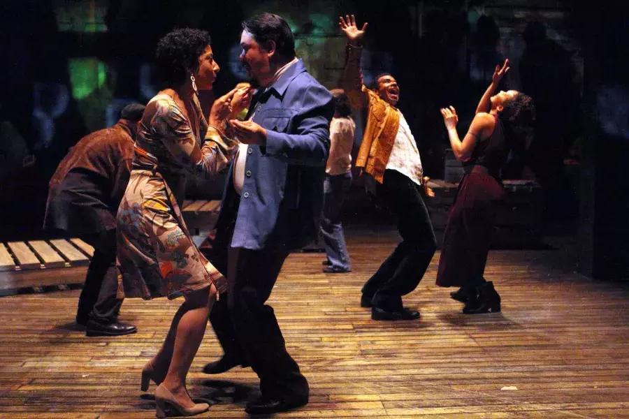 20世纪中期穿着戏服的艺术家们在魔术剧院的舞台上跳舞，表演《爱的匪徒》.