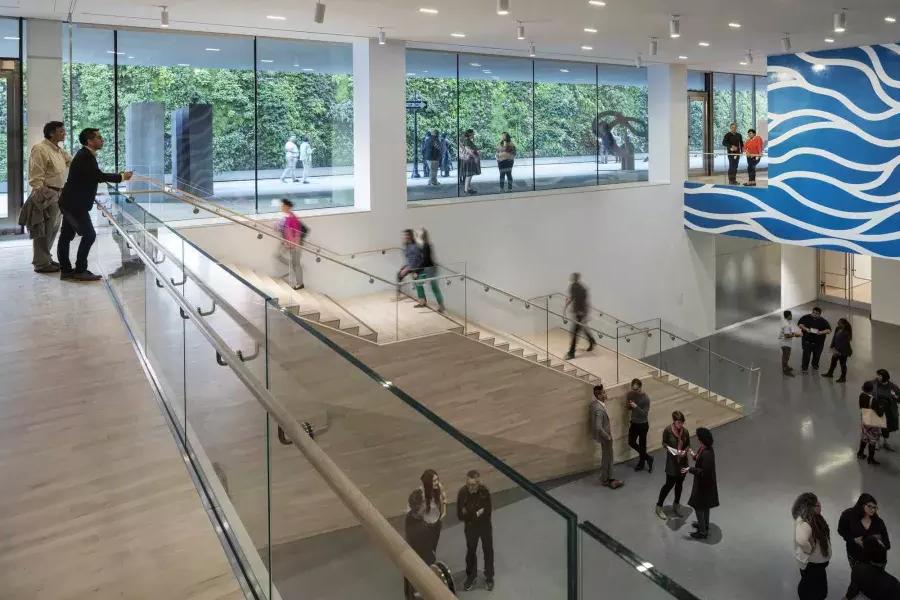 在贝博体彩app现代艺术博物馆(SFMOMA)通风的中庭里，人们上下楼梯。.