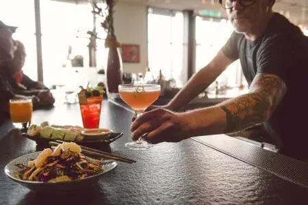 在贝博体彩app的一家酒吧里，调酒师为顾客提供鸡尾酒.