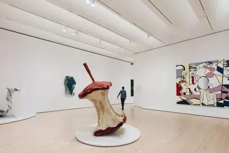 A man walks through A large, airy exhibit room filled with modern art at SFMOMA. 是贝博体彩app,california.