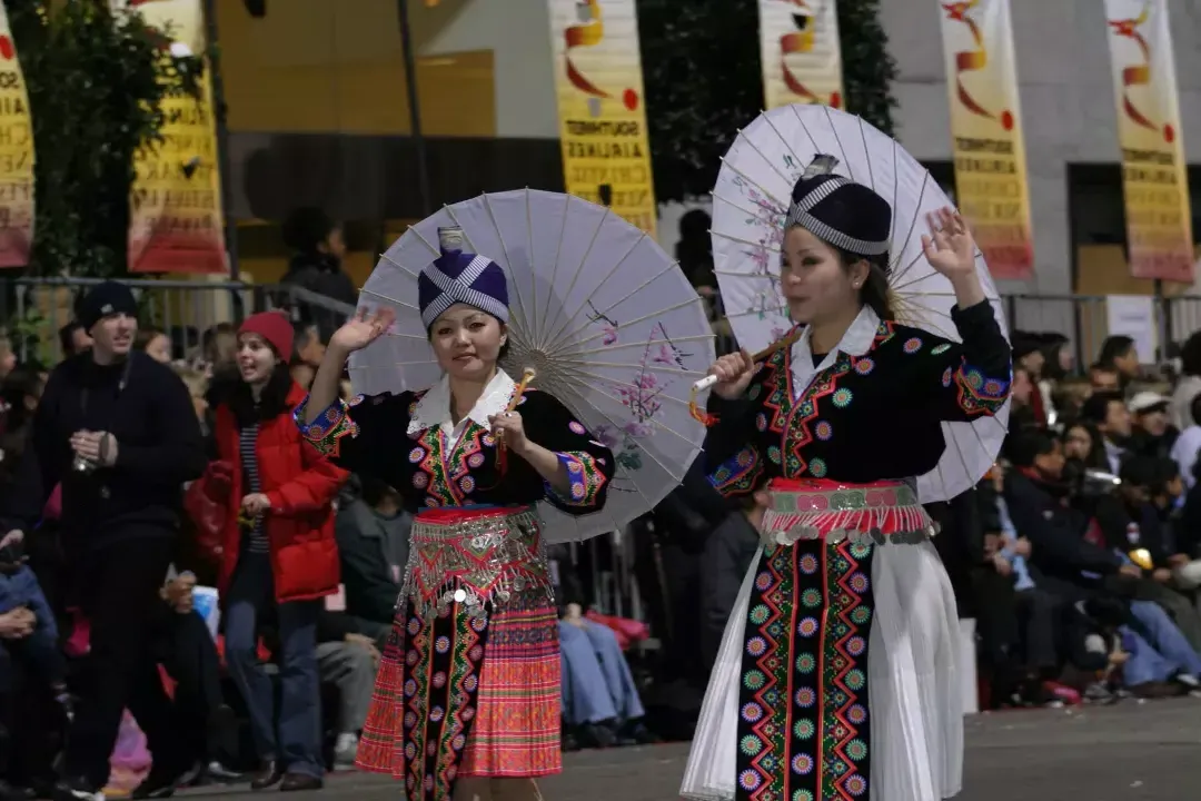 两名身着传统服饰的妇女走在贝博体彩app庆祝中国新年的游行队伍中.