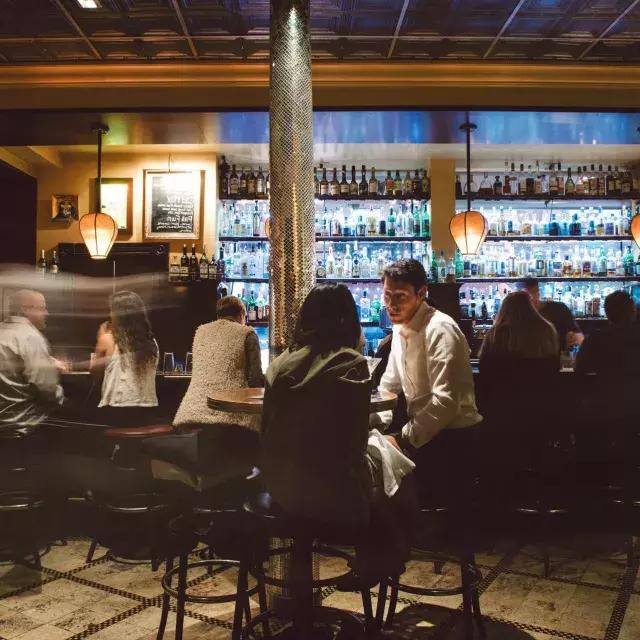 Um casal compartilha bebidas em um bar movimentado de São Francisco.