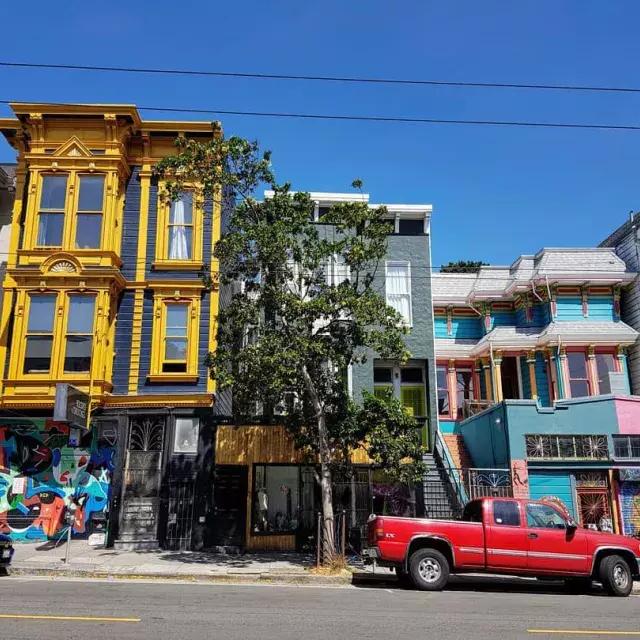 视图 of colorful buildings on Haight Street with cars parked along the street. 贝博体彩app，加利福尼亚.