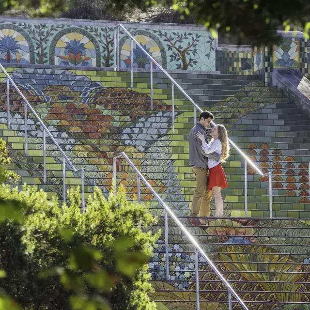 斜着拍的一对情侣站在林肯公园的彩色瓷砖楼梯上的照片