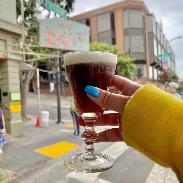 A visitor enjoys an Irish coffee outside the famous Buena Vista Cafe