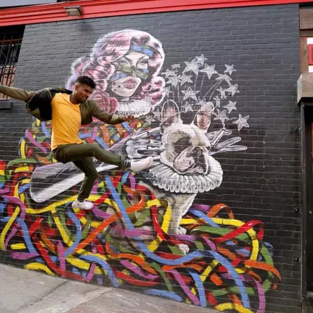 Artista Serge Gay Jr. em frente a um de seus muitos murais.
