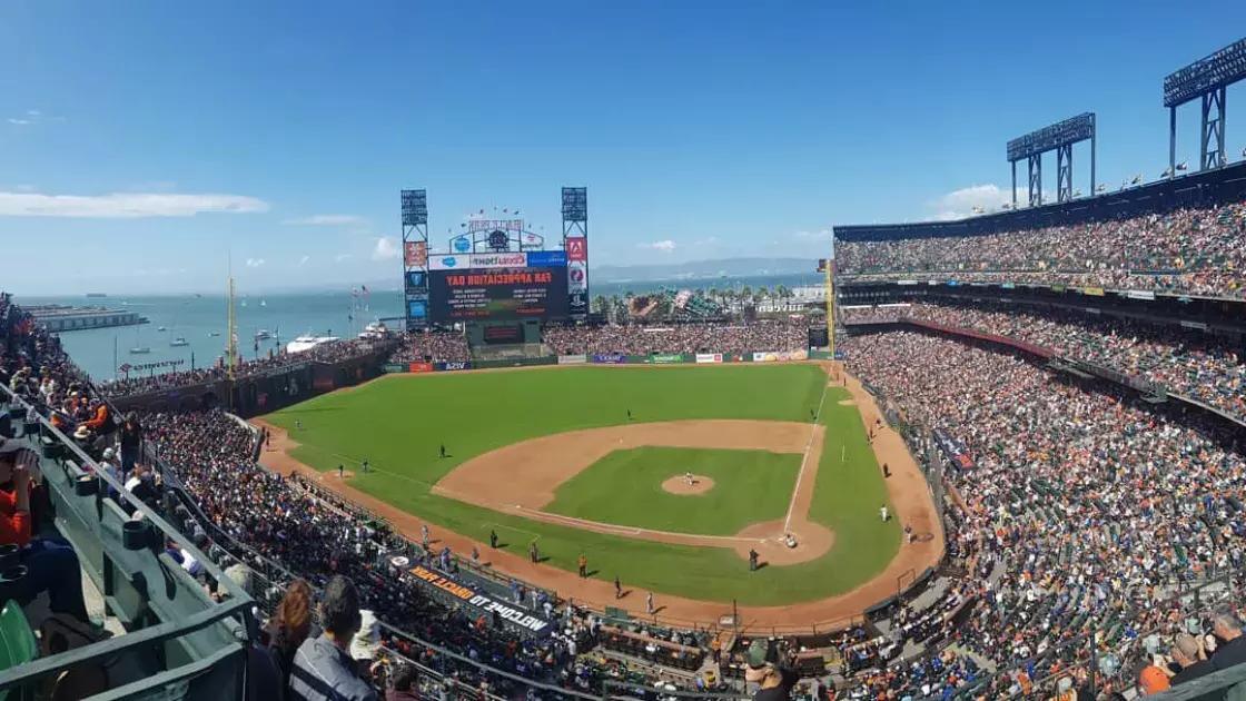 San Francisco's Oracle Park looking out from the stands, with the baseball diamond in the foreground and San Francisco Bay in the background.