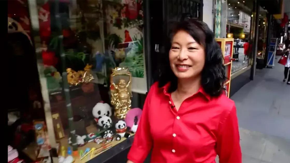 琳达·李走在唐人街的街道上穿着红色的衬衫. 加州贝博体彩app.